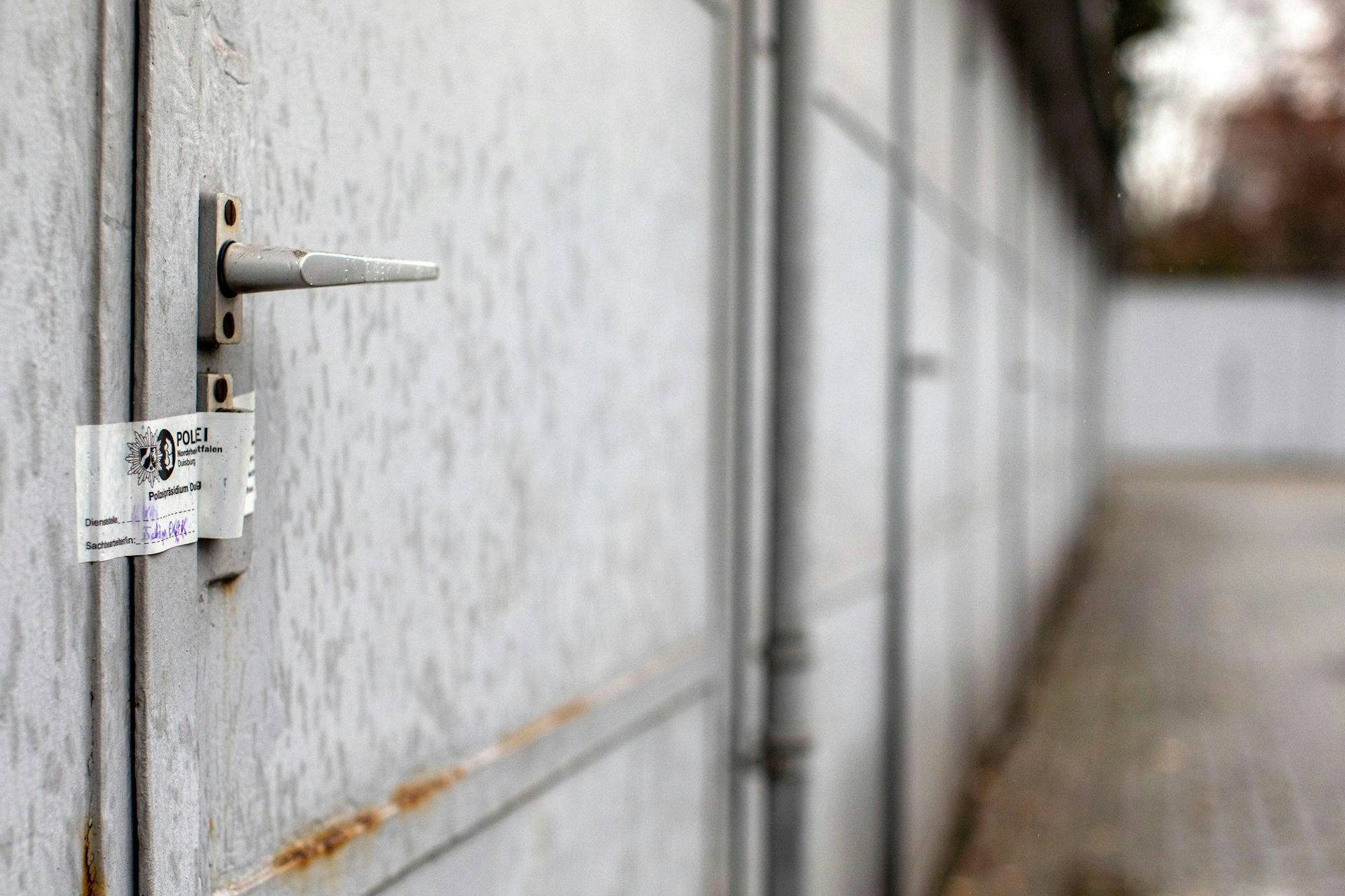 Eine Garagentür ist mit einem Polizeisiegel versehen.