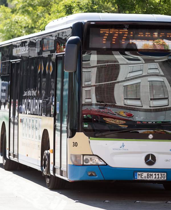 Zwei Busse stehen hintereinander an einem Busbahnhof.