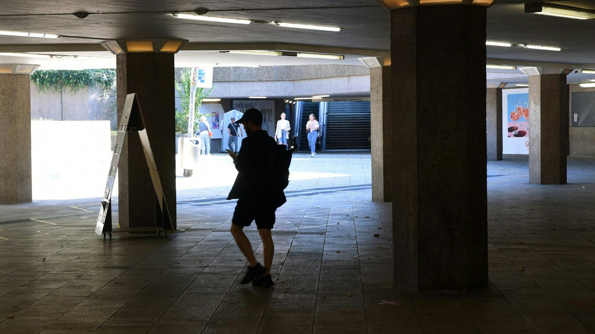 Ein Mann geht durch eine dunkle Passage.