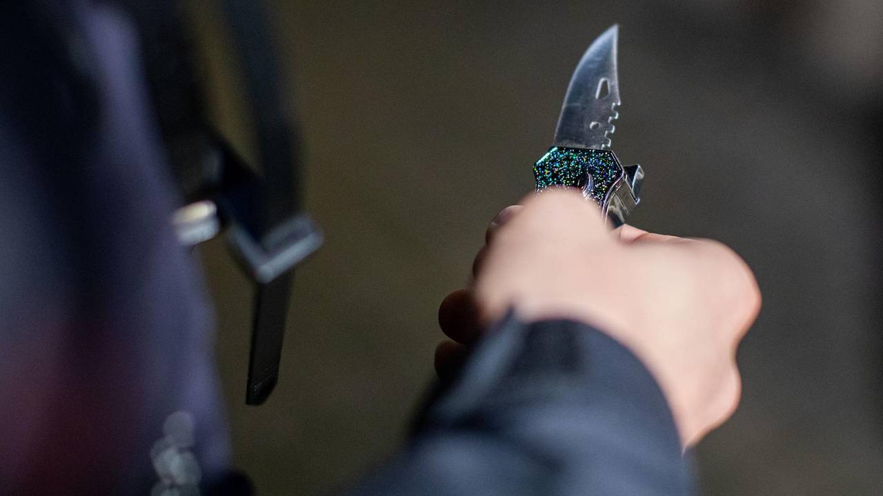 Ein Polizist hält ein sichergestelltes Messer in der Hand.
