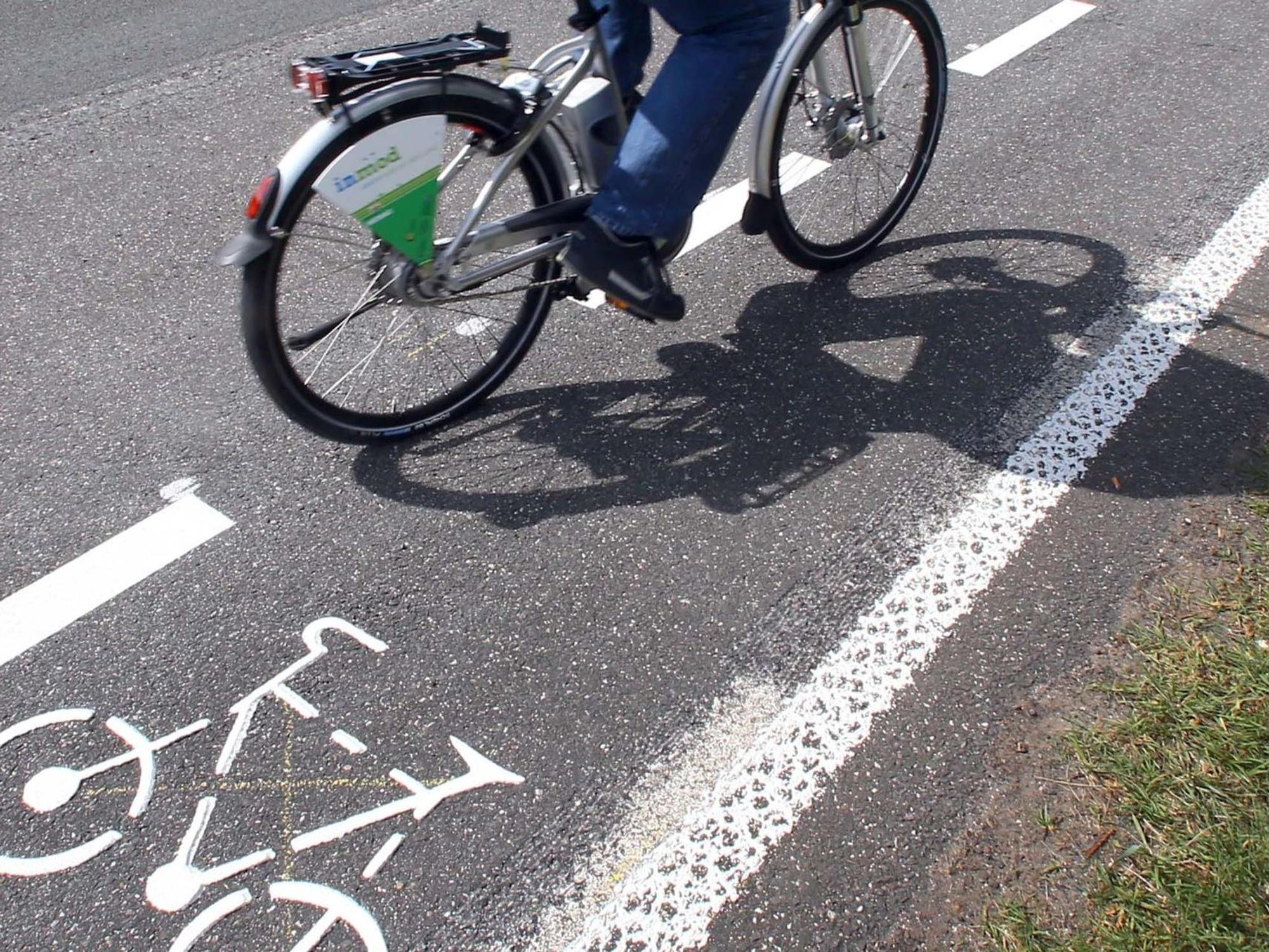 Ein Fahrradfahrer ist auf einem Radweg unterwegs.