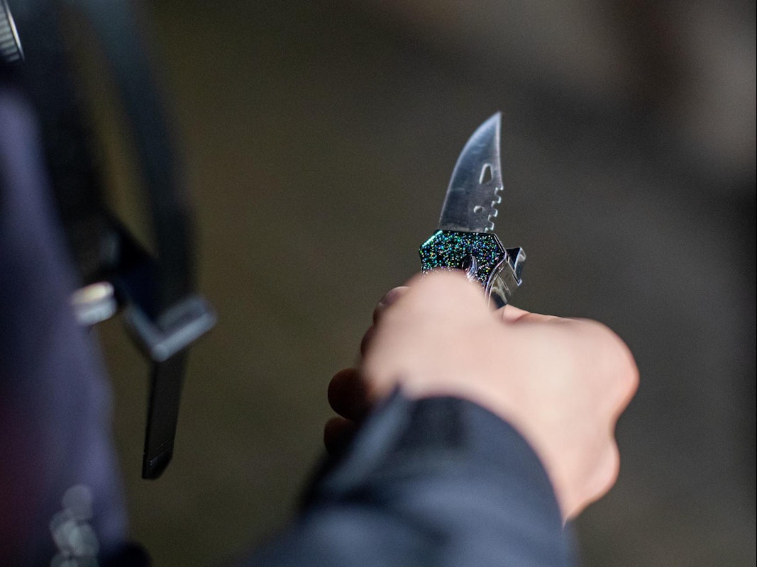 Ein Mann hält ein aufgeklapptes Messer in der Hand.