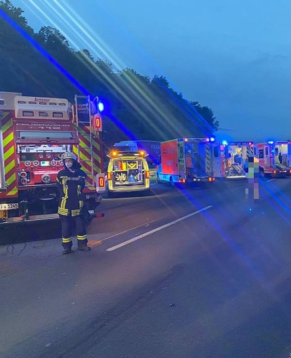 Einsatzkräfte der Feuerwehr stehen nach einem Unfall auf der A3.