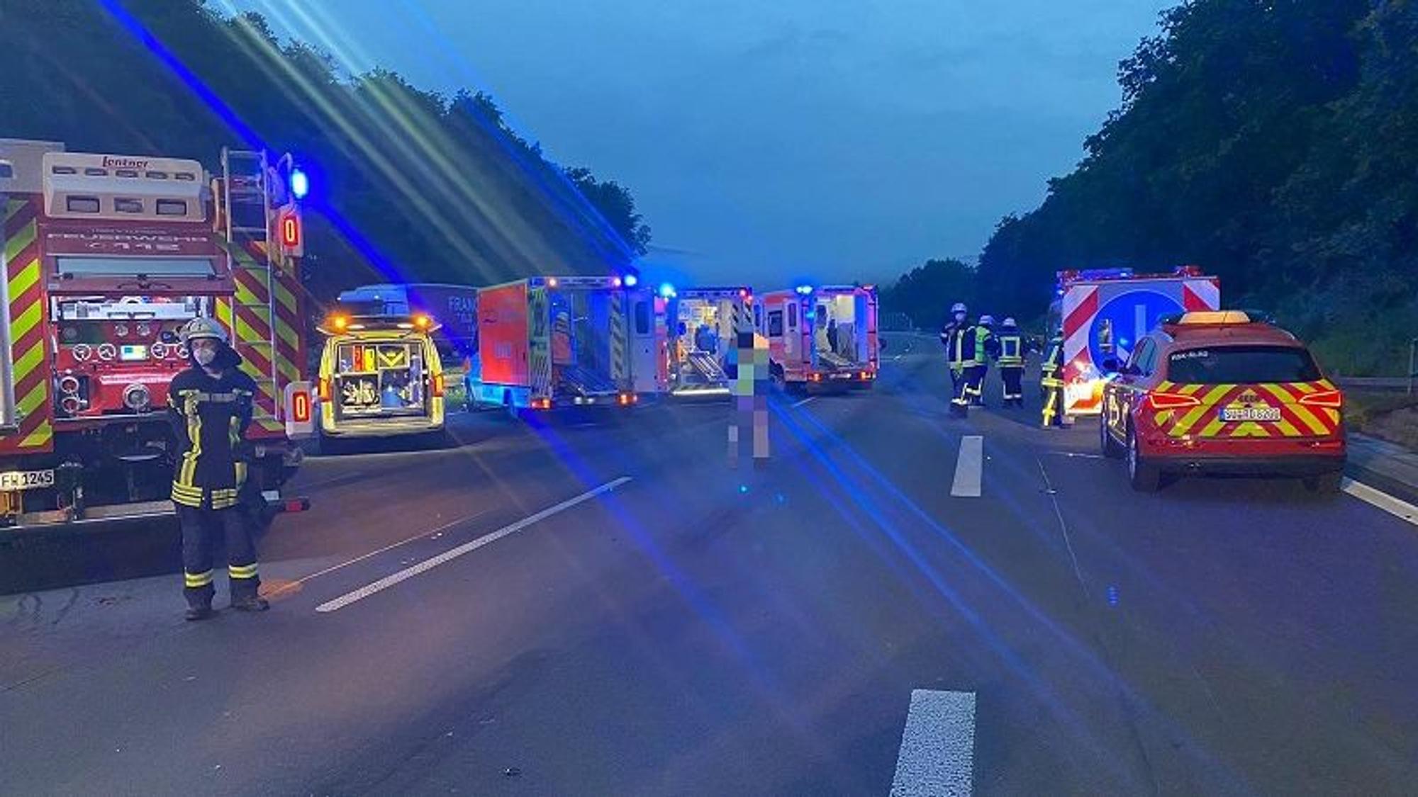 Einsatzkräfte der Feuerwehr stehen nach einem Unfall auf der A3.