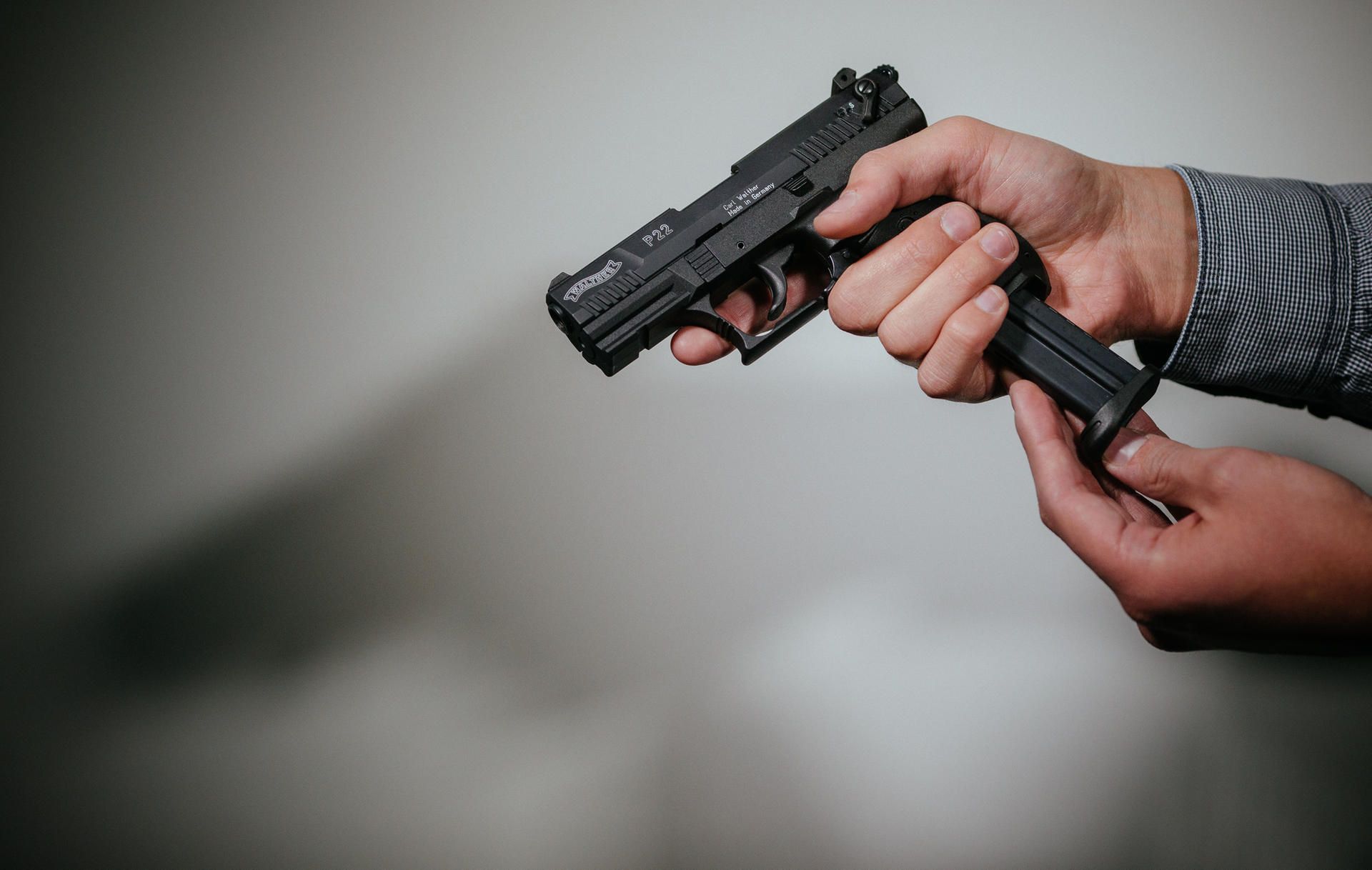 Ein Mann hält eine Waffe.