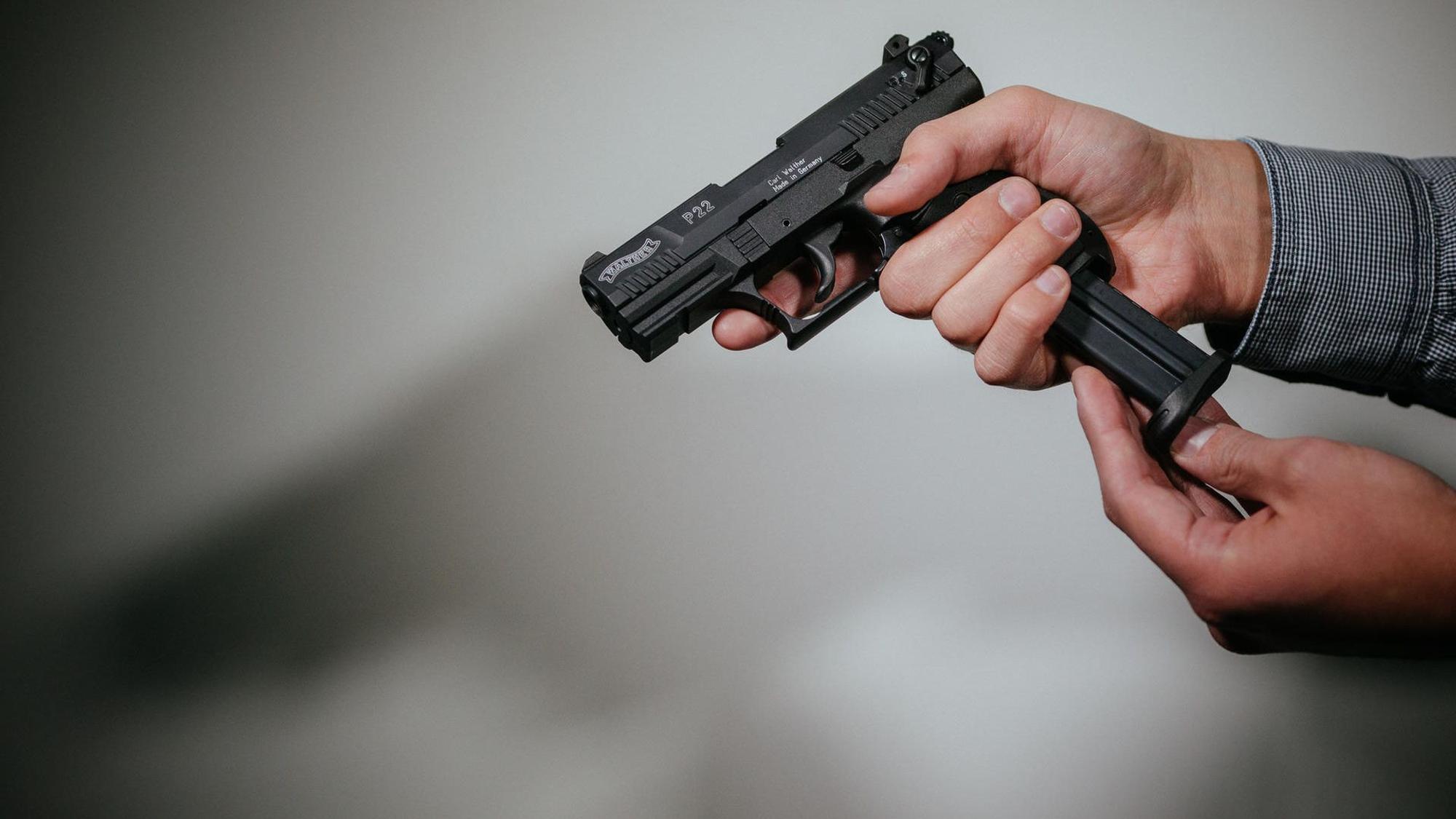 Ein Mann hält eine Waffe.