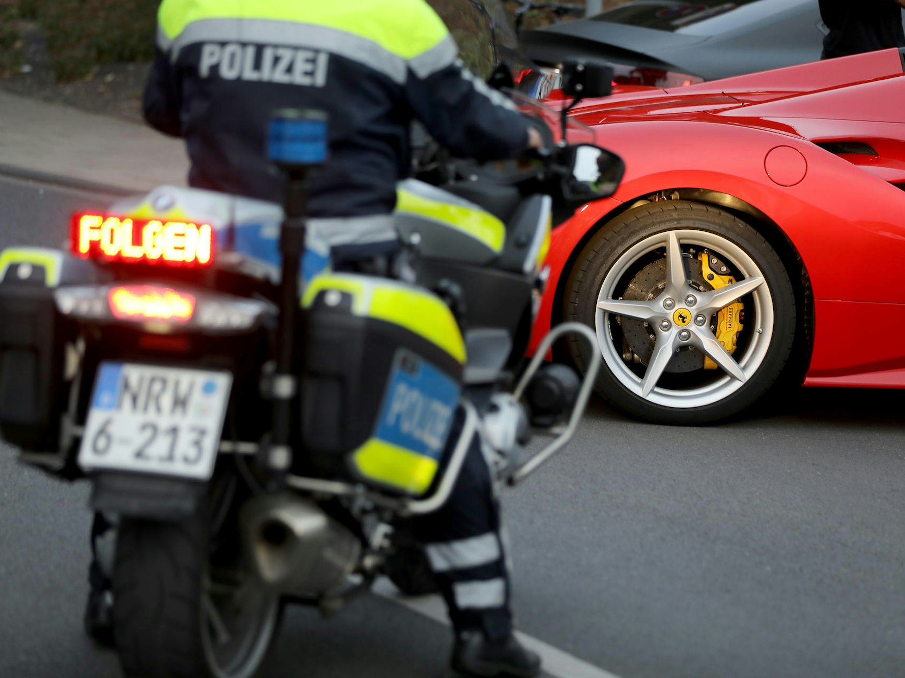 Ein Motorradpolizist hat einen Ferrari angehalten.