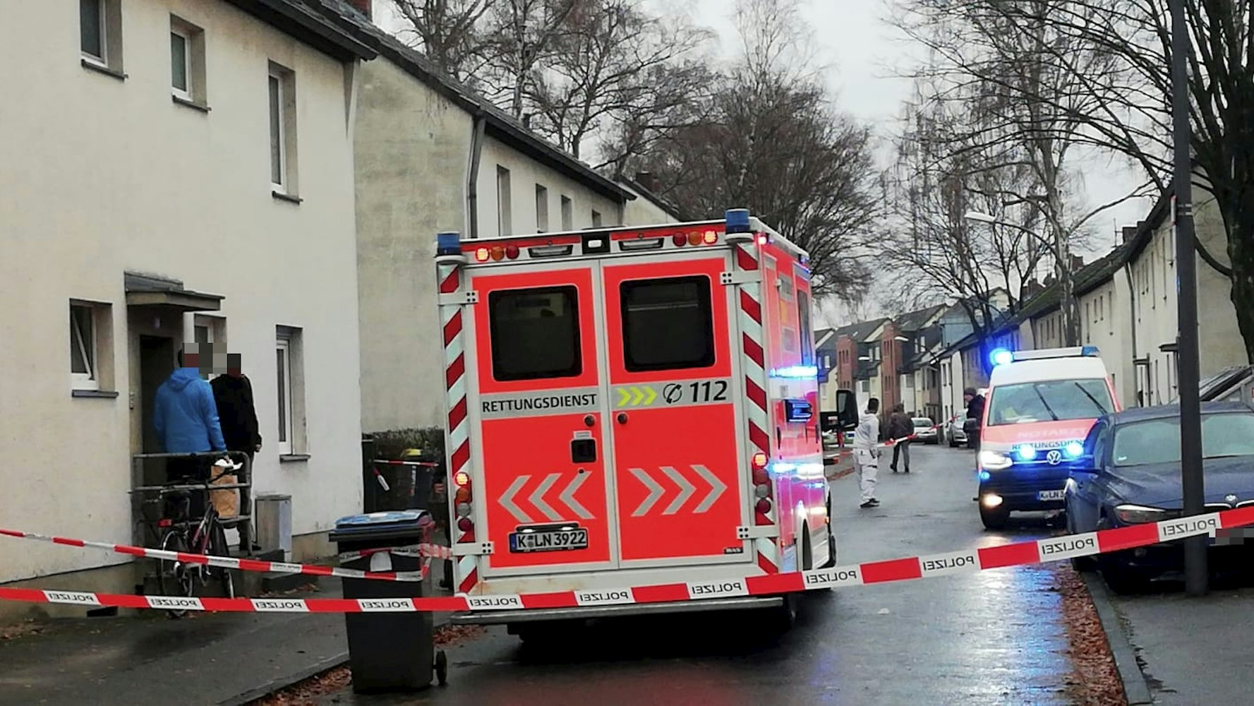 Einsatzfahrzeuge stehen auf der abgesperrten Straße.