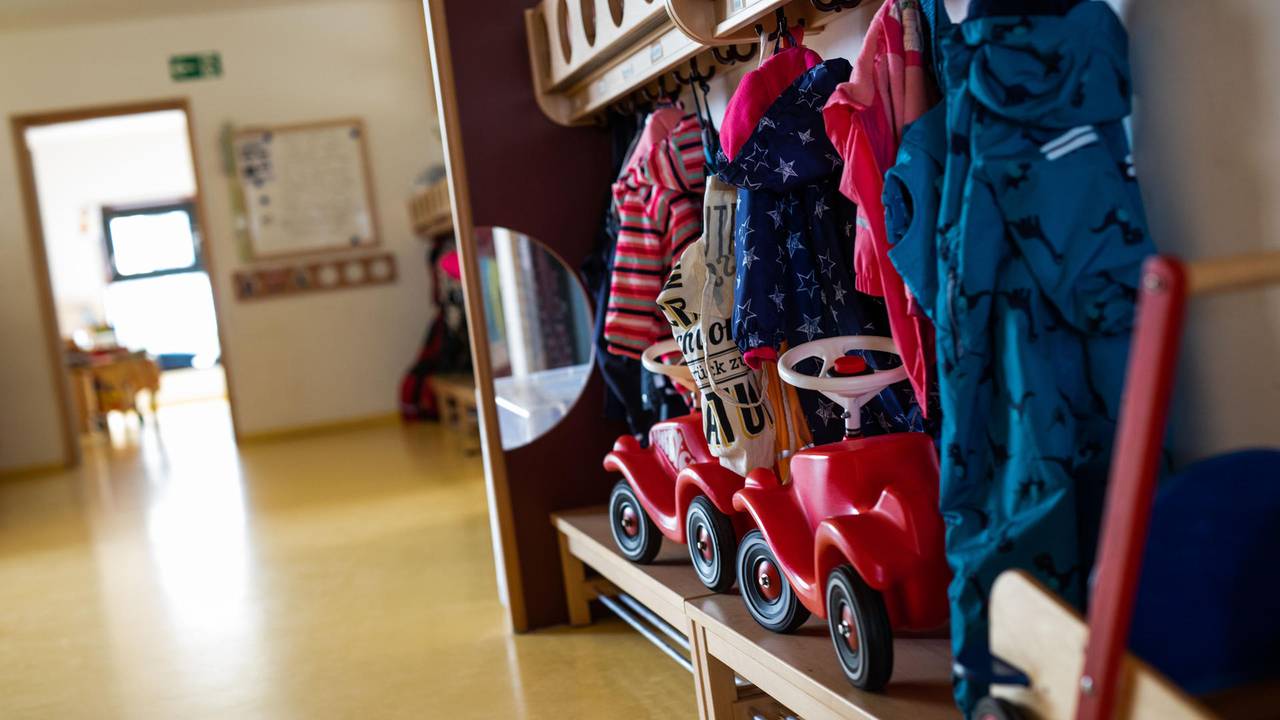 Die Garderobe einer Kita mit Jacken und Bobbycars