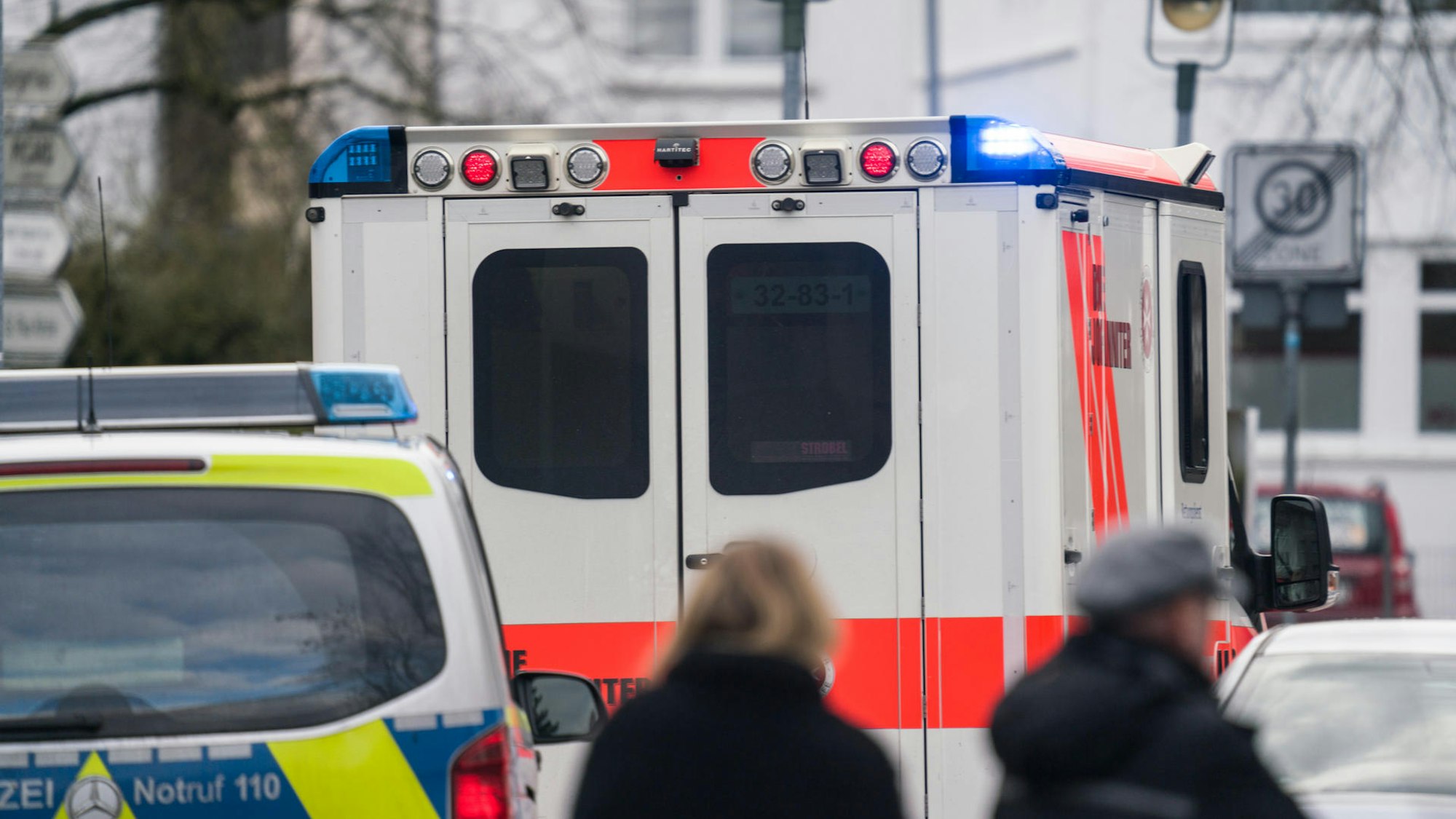 Ein Rettungswagen und ein Streifenwagen stehen auf einer Straße.