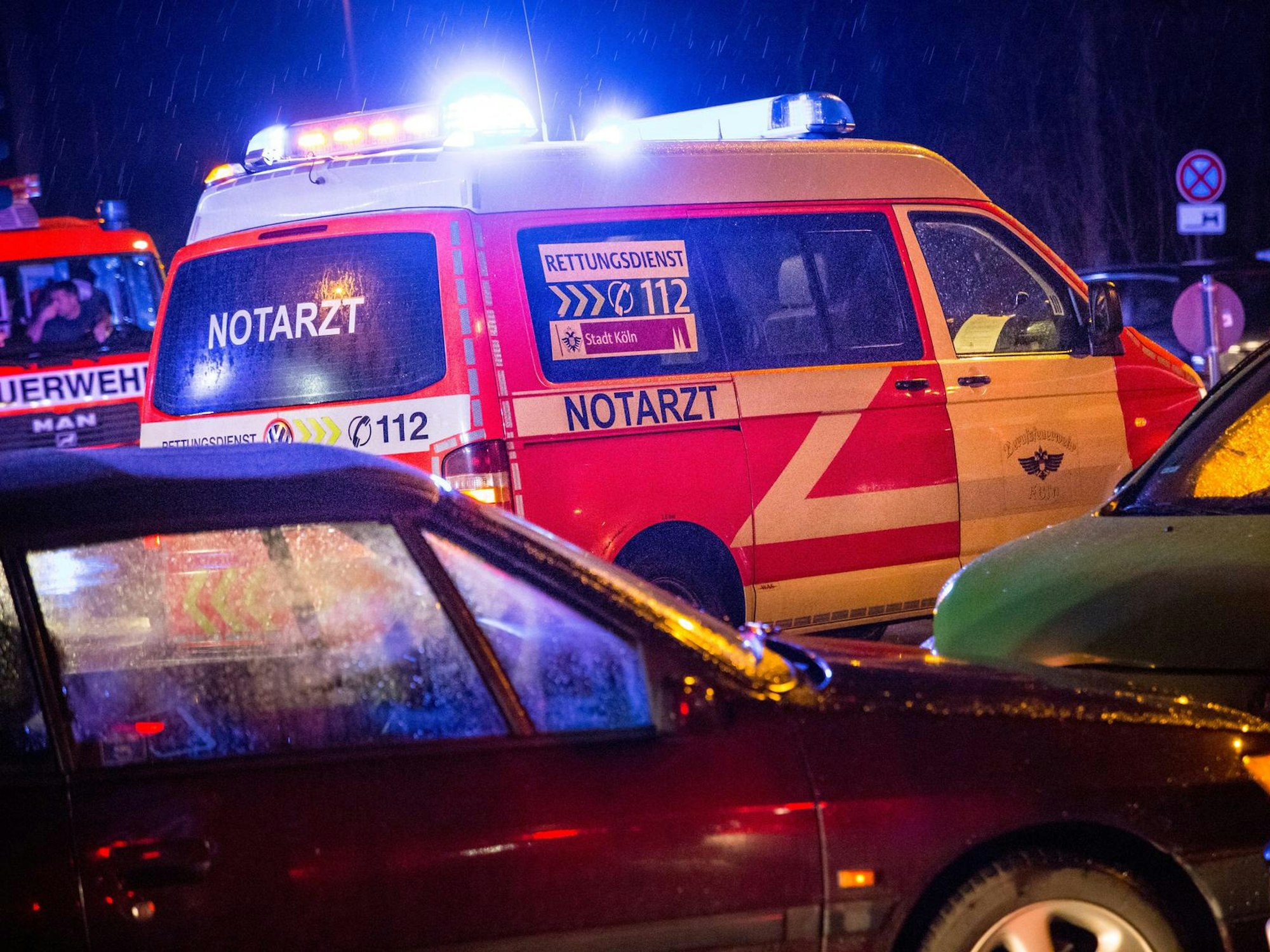 Rettungswagen steht mit Blaulicht von Autos umgeben.