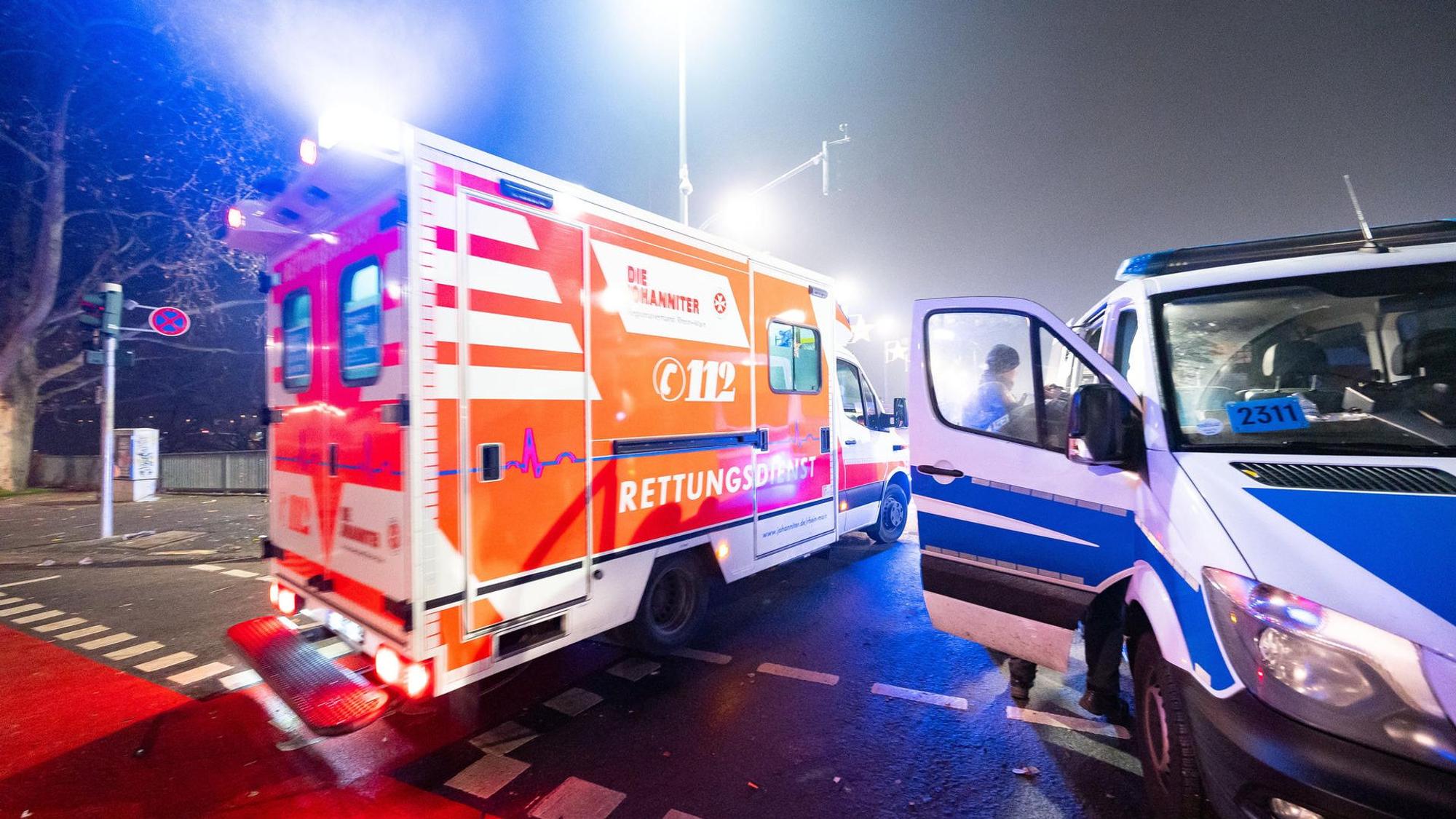 Ein Rettungswagen und ein Polizeiwagen stehen auf einer Kreuzung.