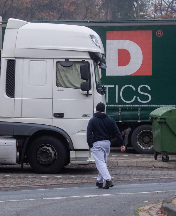 Drei Lkw stehen an einem Autobahnrasthof.