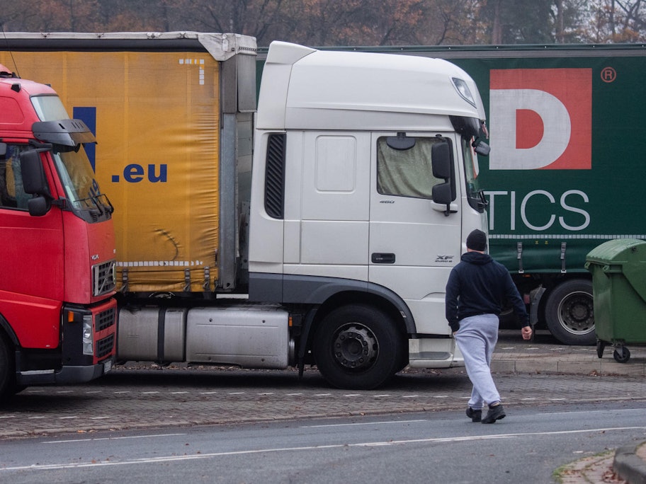 Lkw stehen auf einem Parkplatz an der Autobahn.