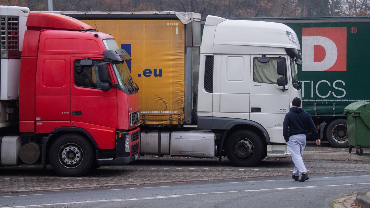 Drei Lkw stehen an einem Autobahnrasthof.