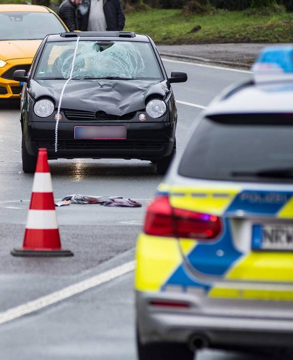 Polizei und Rettungsdienst sind auf einer Straße zu sehen.