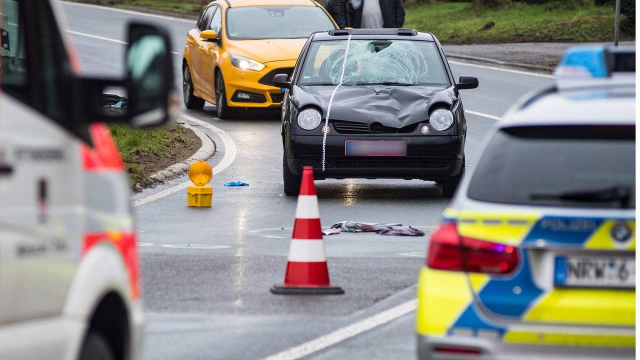 Polizei und Rettungsdienst sind auf einer Straße zu sehen.