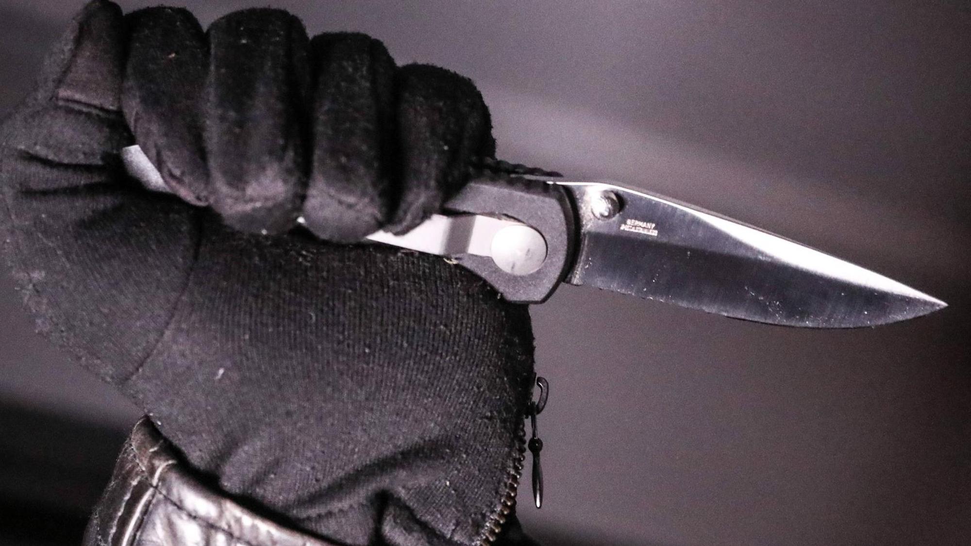 Unbekannter Mann hält Messer ein Messer in der Hand.
