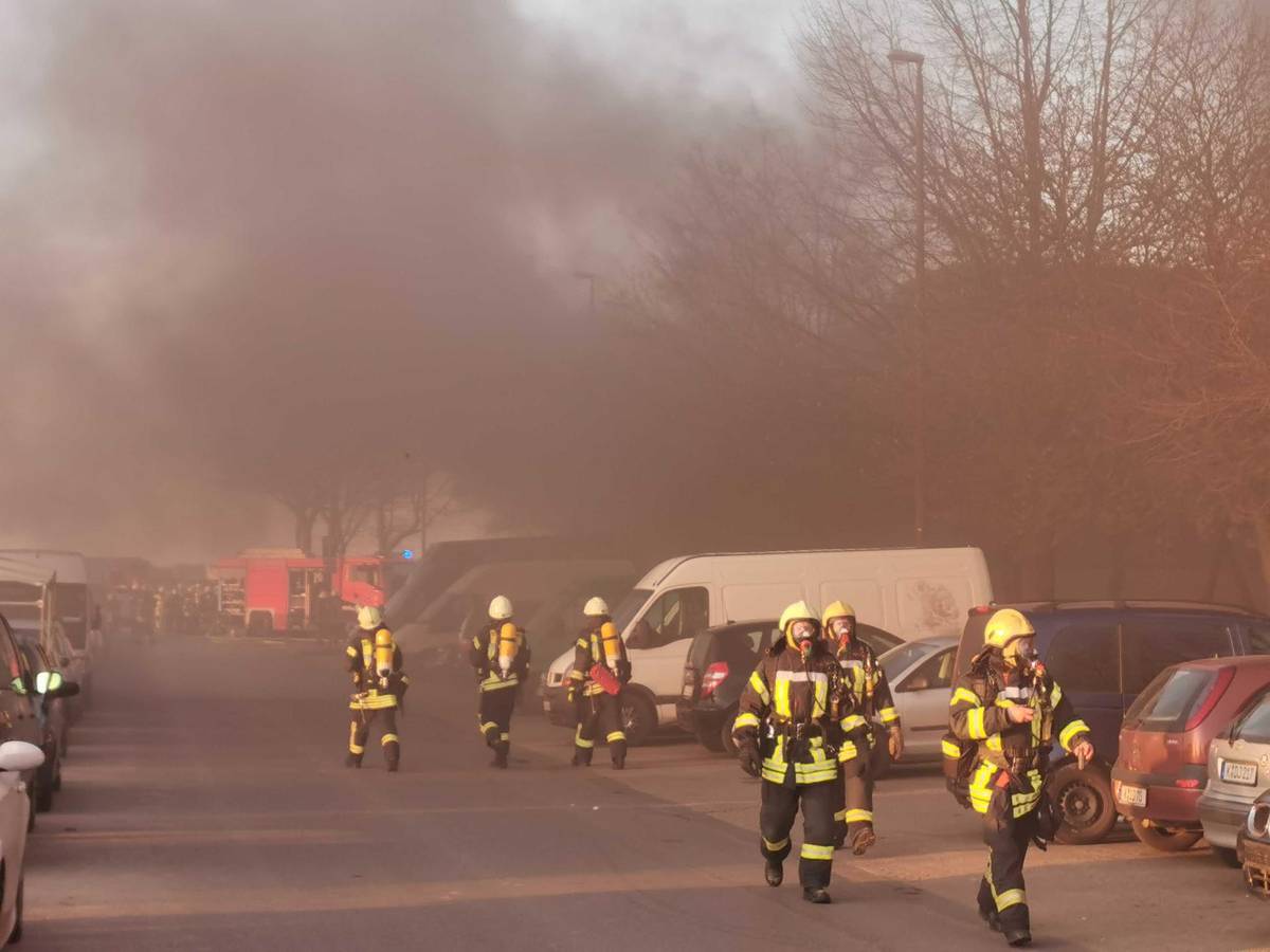 Feuerwehrleute im Einsatz, im Hintergrund starker Rauch.