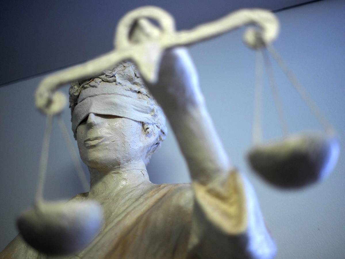 Eine Statue der Justitia steht in einem Gebäude.