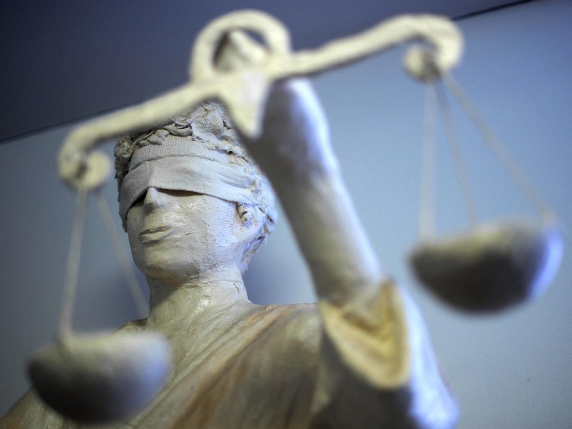 Eine Statue der Justitia steht in einem Gebäude.