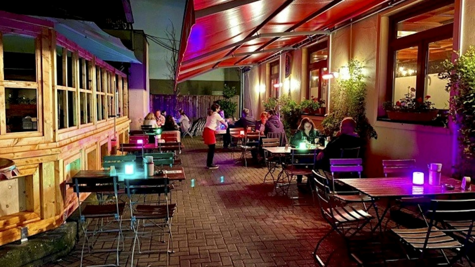 Gäste sitzen draußen im Haus Unkelbach an Tischen