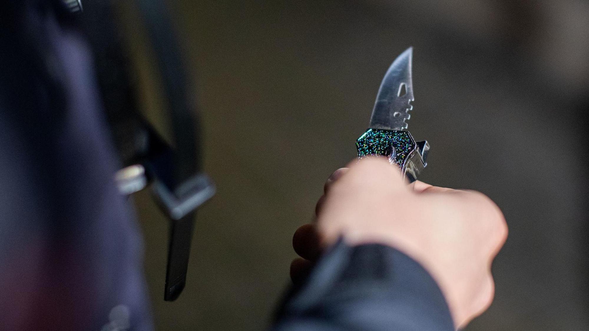 Ein Mann hält ein Messer in der Hand.