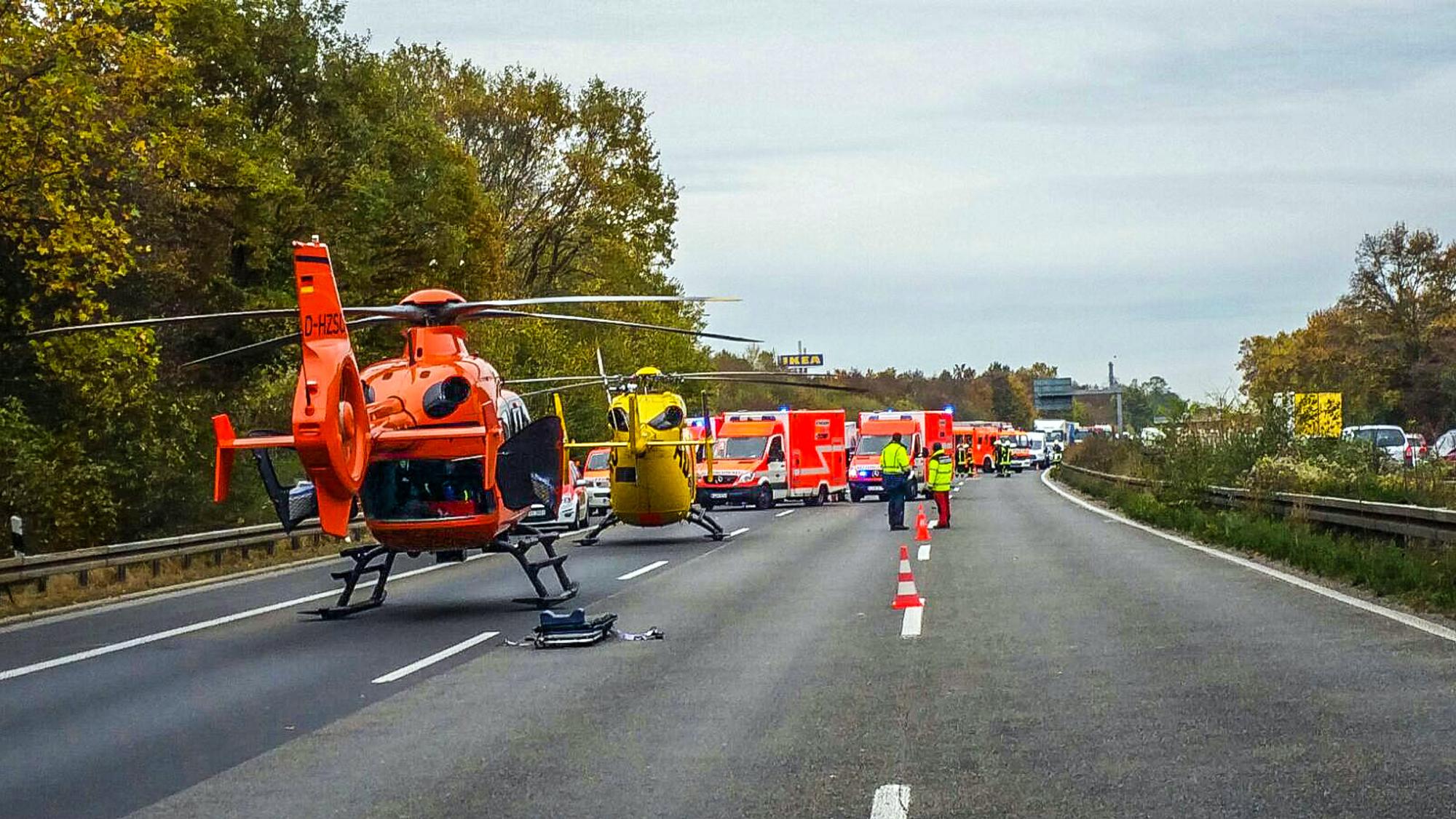 Zwei Rettungshubschrauber sind auf einer Fahrbahn gelandet. Auch mehrere Rettungswagen stehen dort.