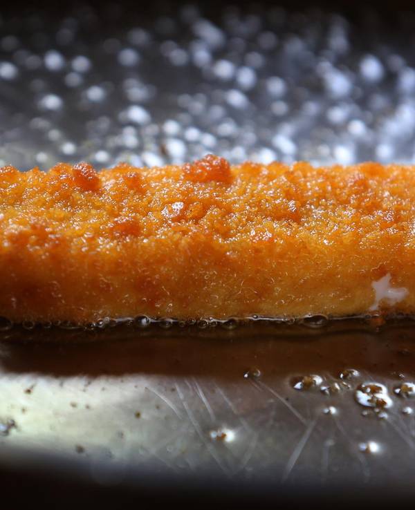 Ein Fischstäbchen in einer Pfanne. Fischstäbchen im Test: Öko-Test hat zahlreiche Produkte unter die Lupe genommen. Leider sind nicht alle Fischstäbchen empfehlenswert. Zu sehen ist ein undatiertes Symbolbild.