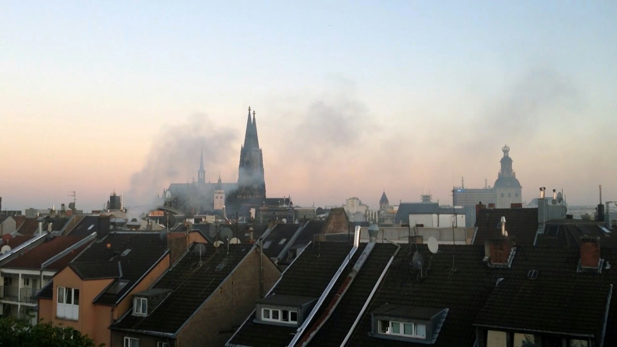 Grillrauch zeiht über die Dächer von Wohnhäusern.