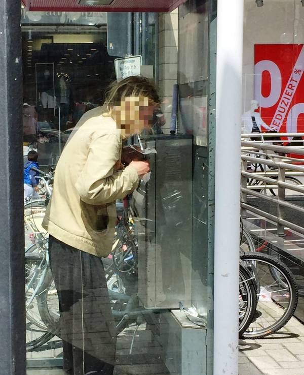 Ein Mann konsumiert Heroin in einer Telefonzelle.