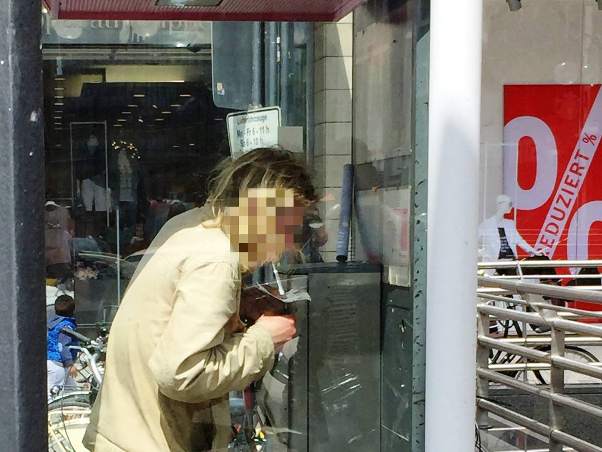 Ein Mann konsumiert Heroin in einer Telefonzelle.