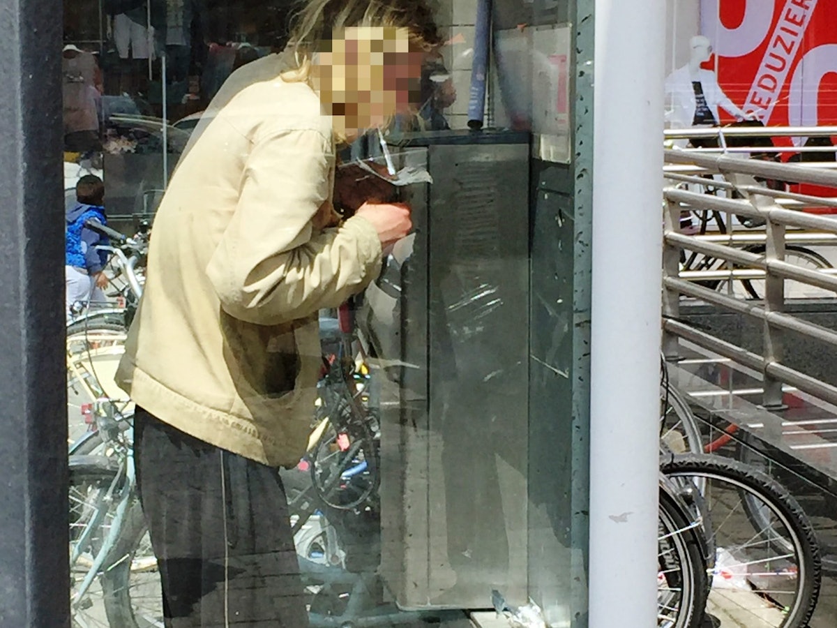 Ein Mann konsumiert Heroin in einer Telefonzelle.