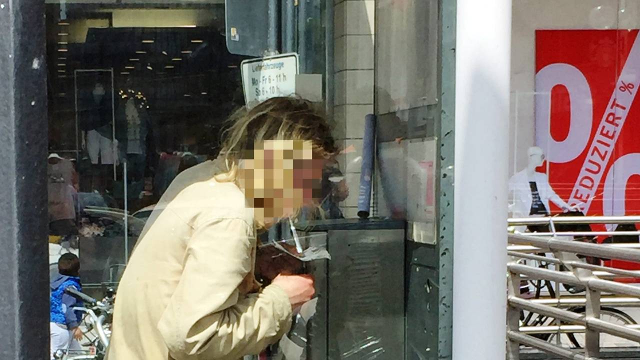 Ein Mann konsumiert Heroin in einer Telefonzelle.