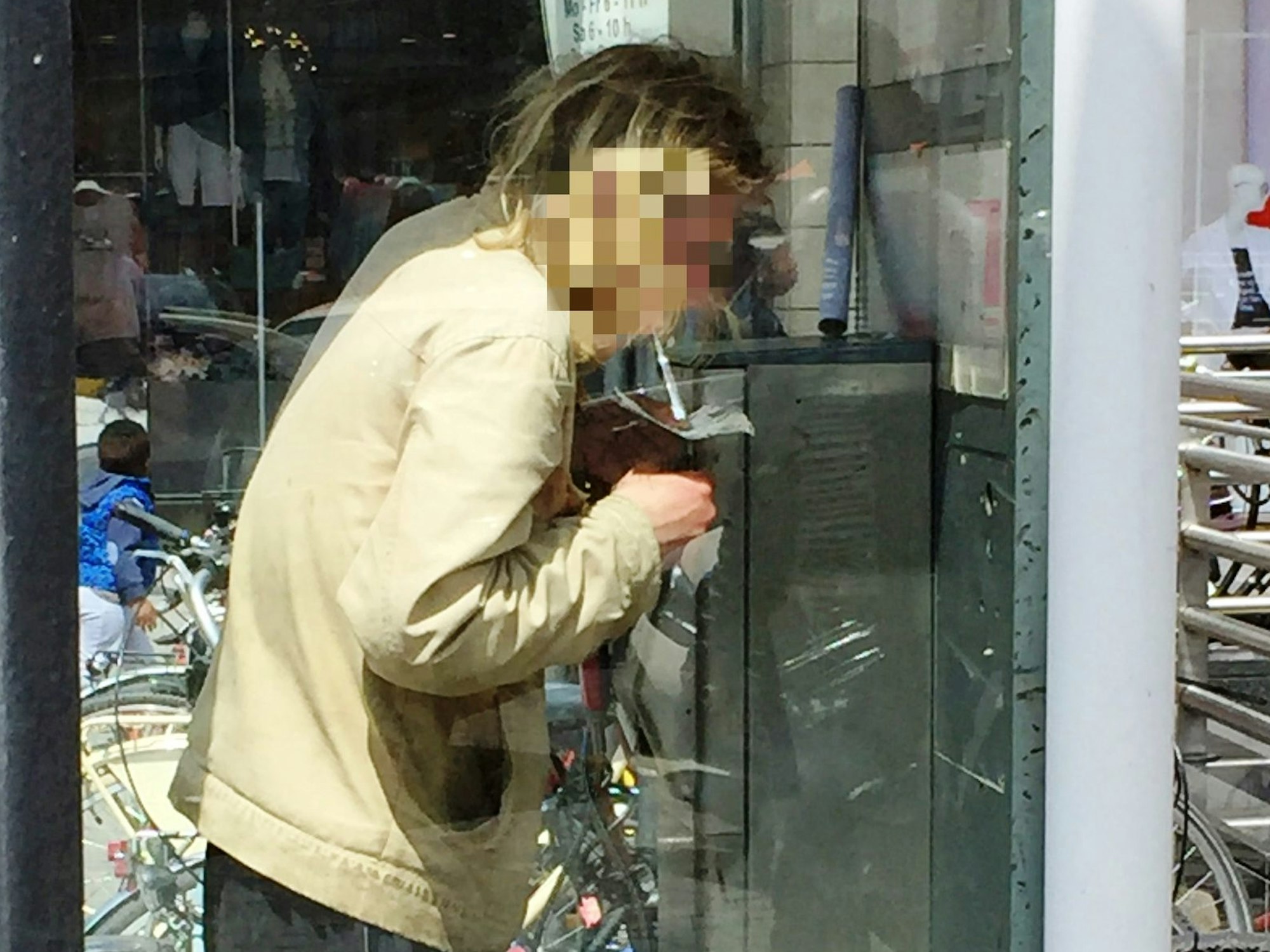 Ein Mann konsumiert Heroin in einer Telefonzelle.