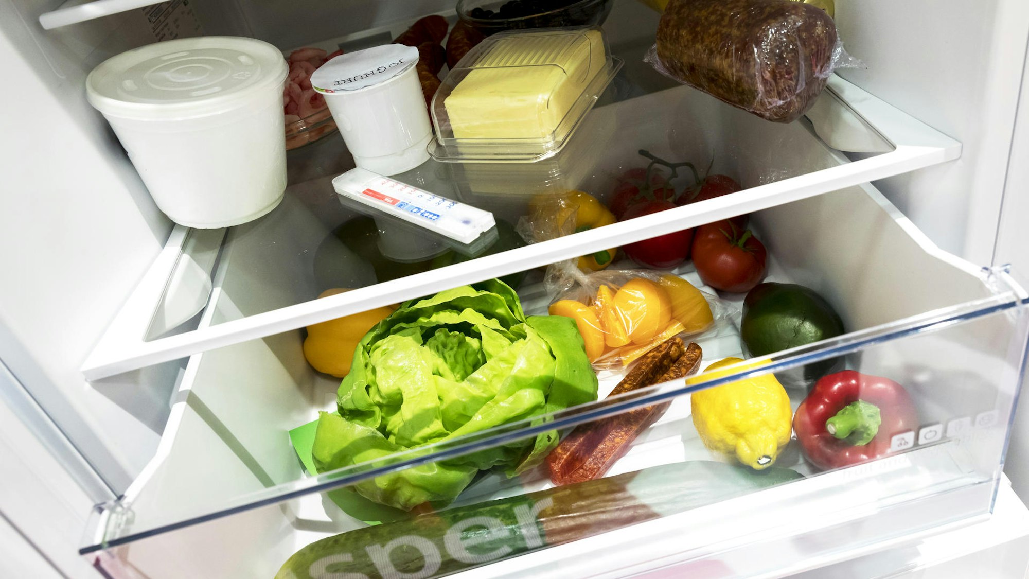 Das Foto zeigt einen gefüllten Kühlschrank mit Obst und Gemüse.