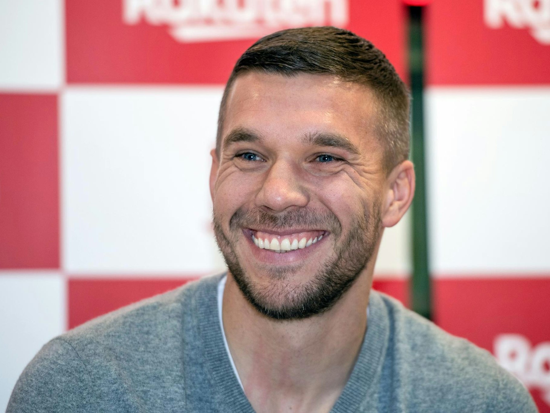 Lukas Podolski lächelt in die Kamera.