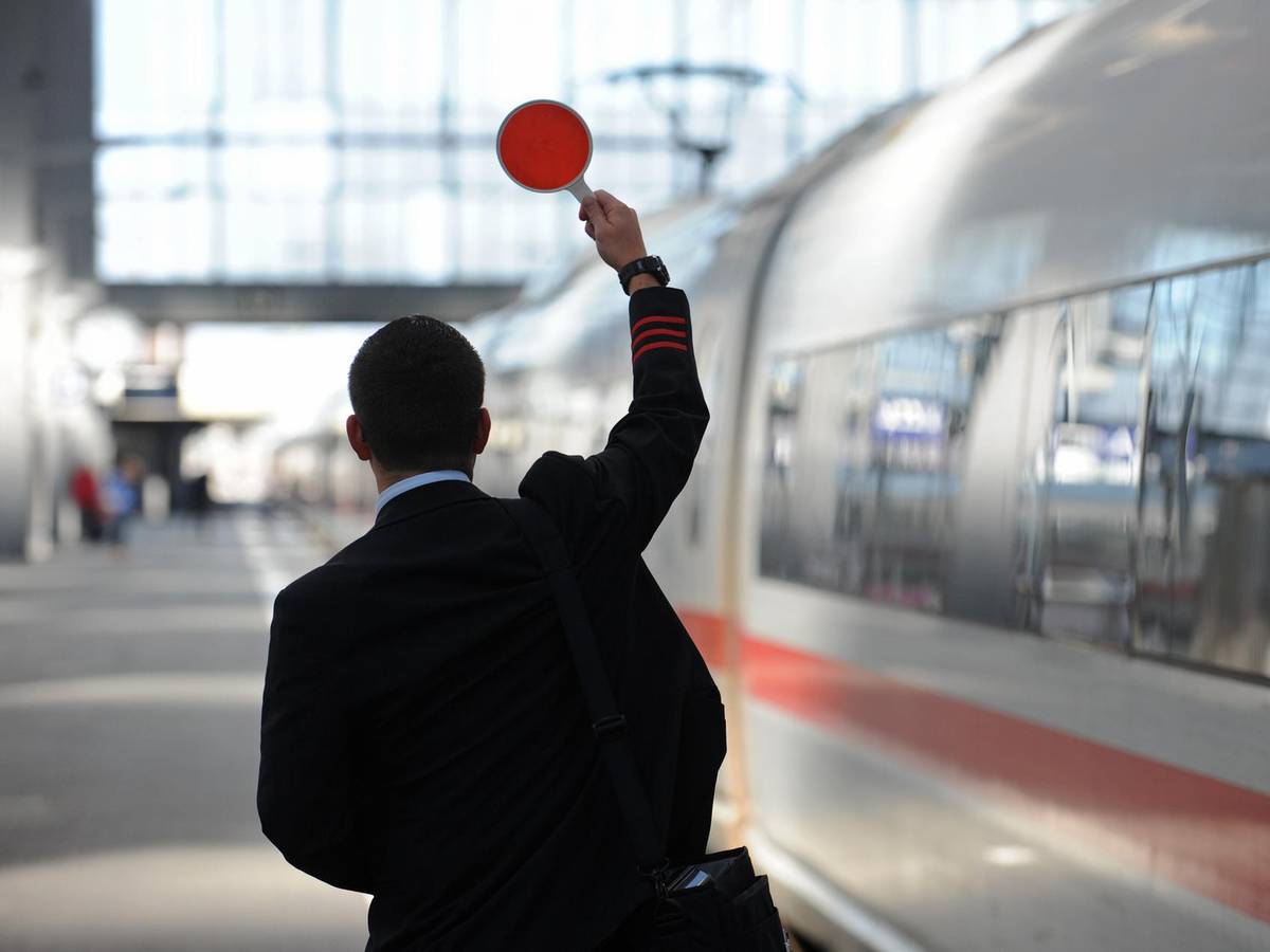 Kölner Hauptbahnhof: Zugbegleiter steht am Bahnsteig.