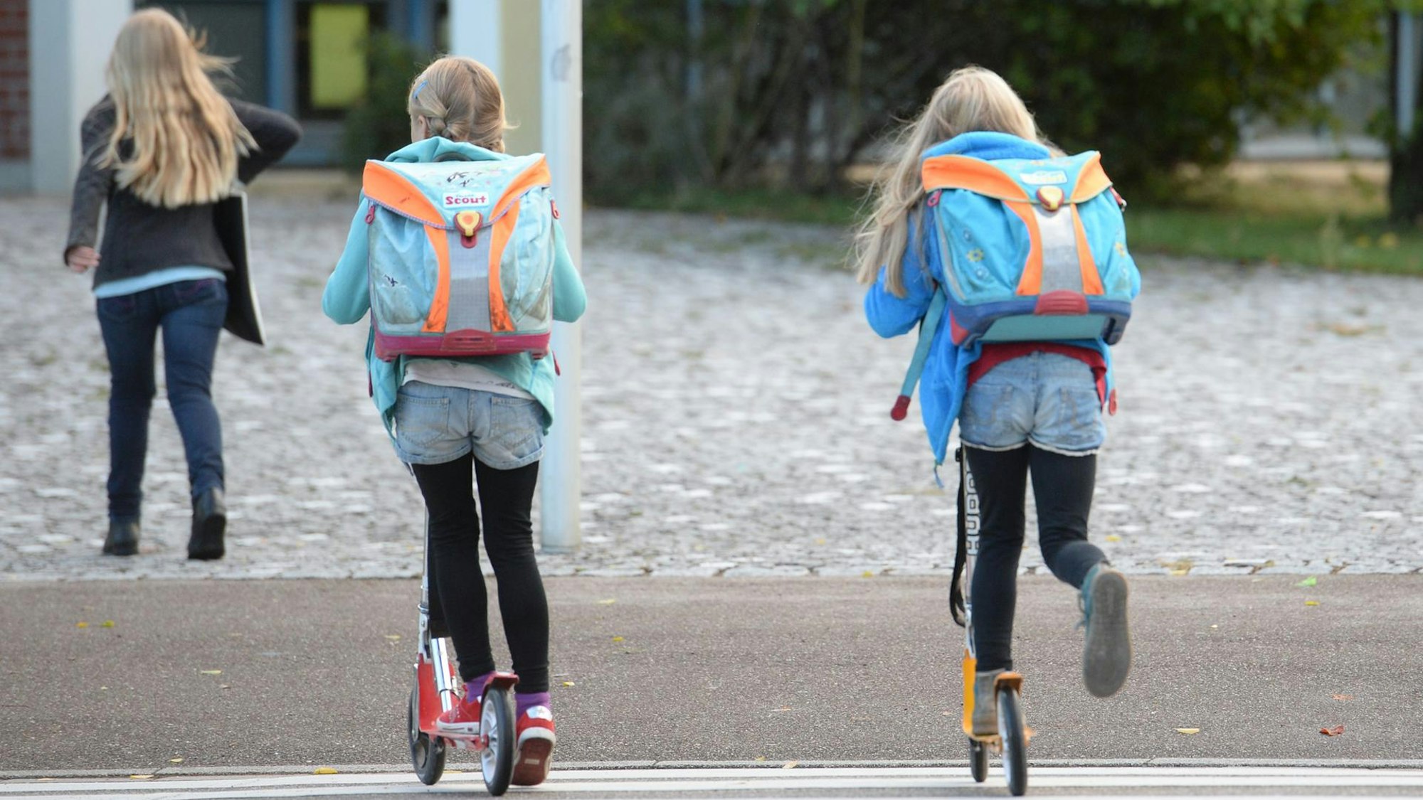 Kinder fahren auf Tretrollern.