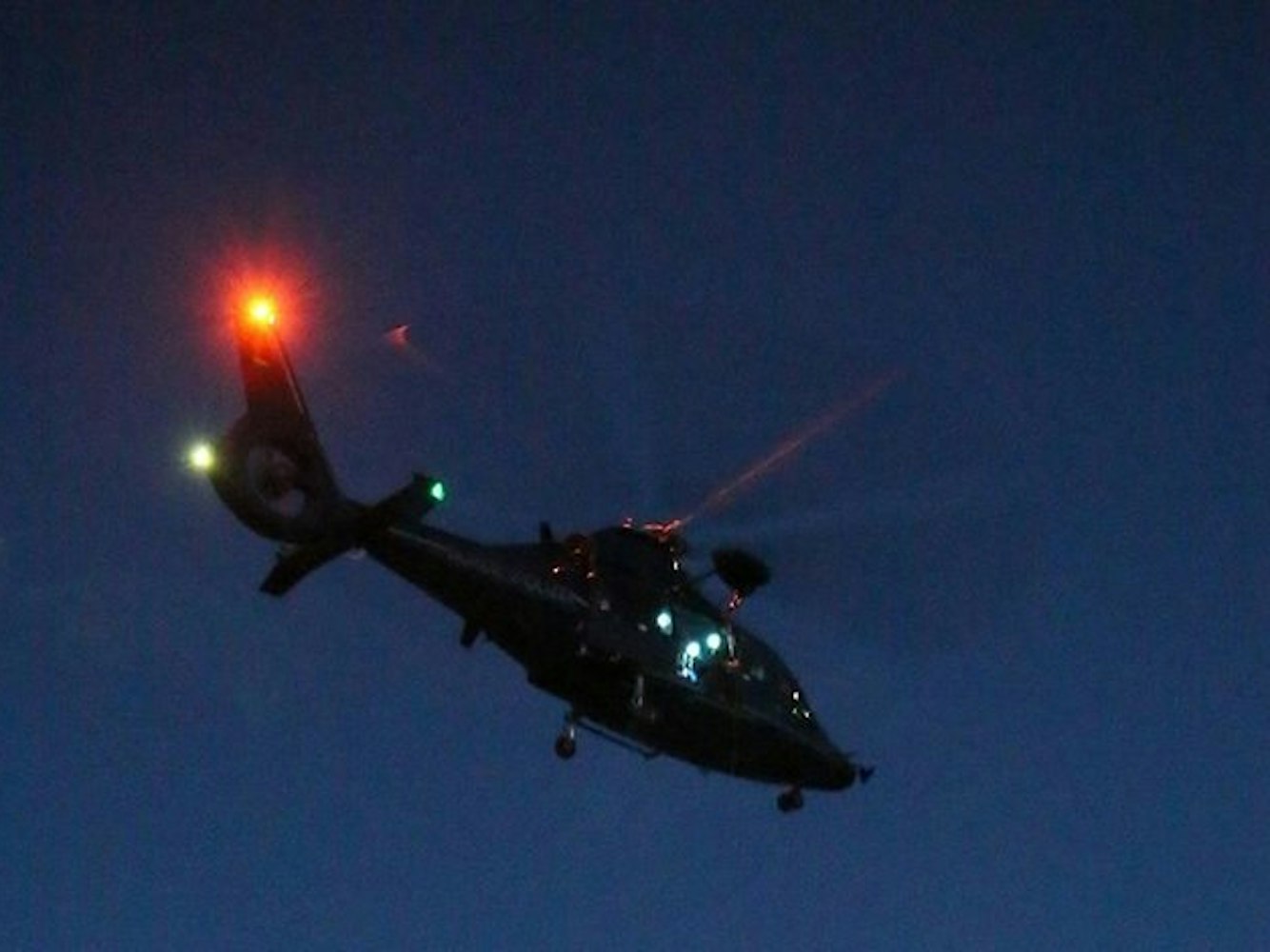 Ein Hubschrauber ist in der Nacht in der Luft.
