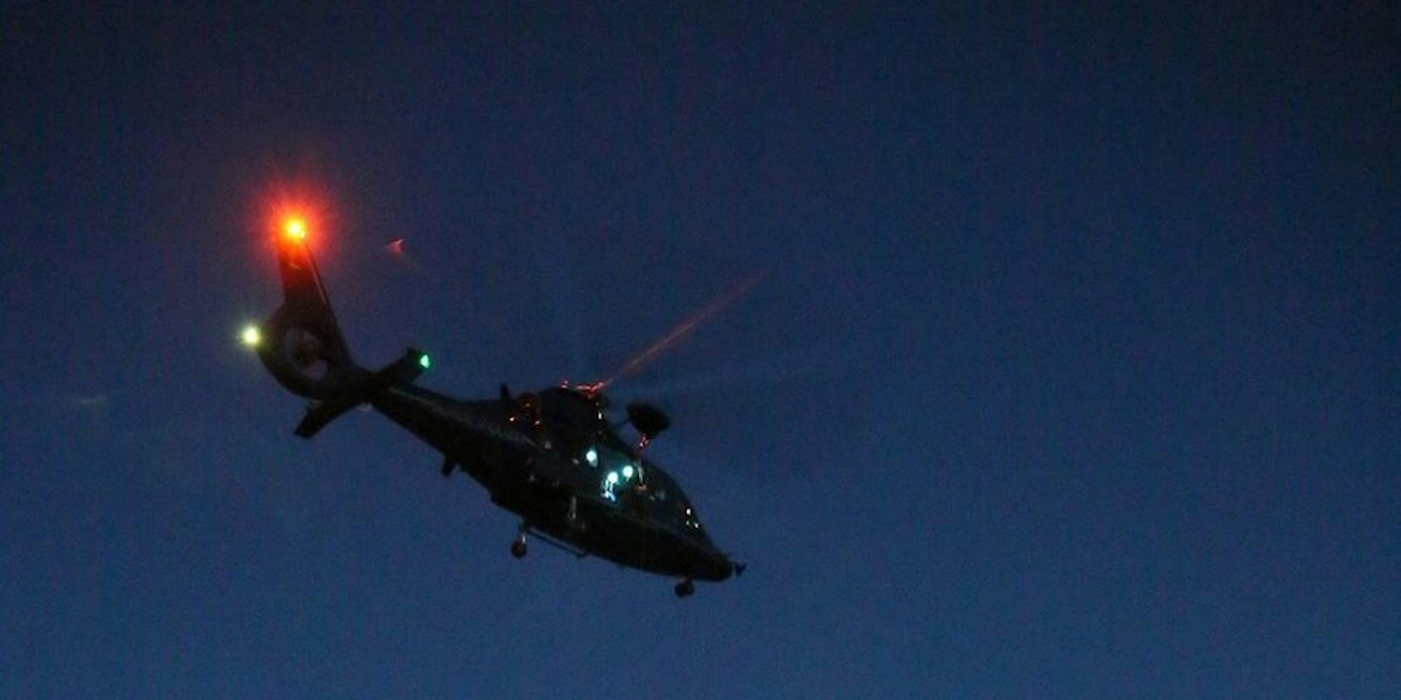 Ein Hubschrauber fliegt nachts.