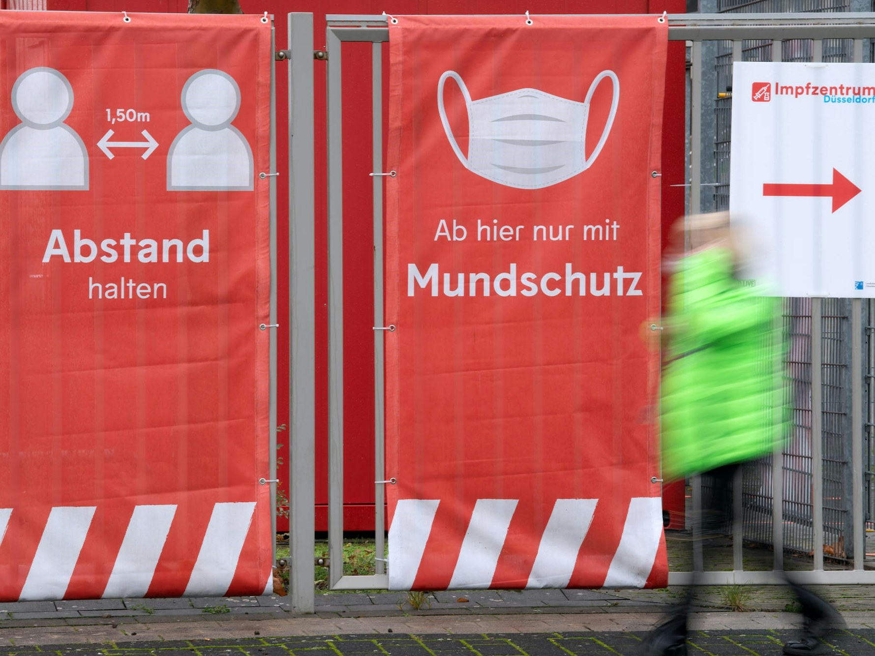 Ein Mann läuft an einem Impfzentrum vorbei.
