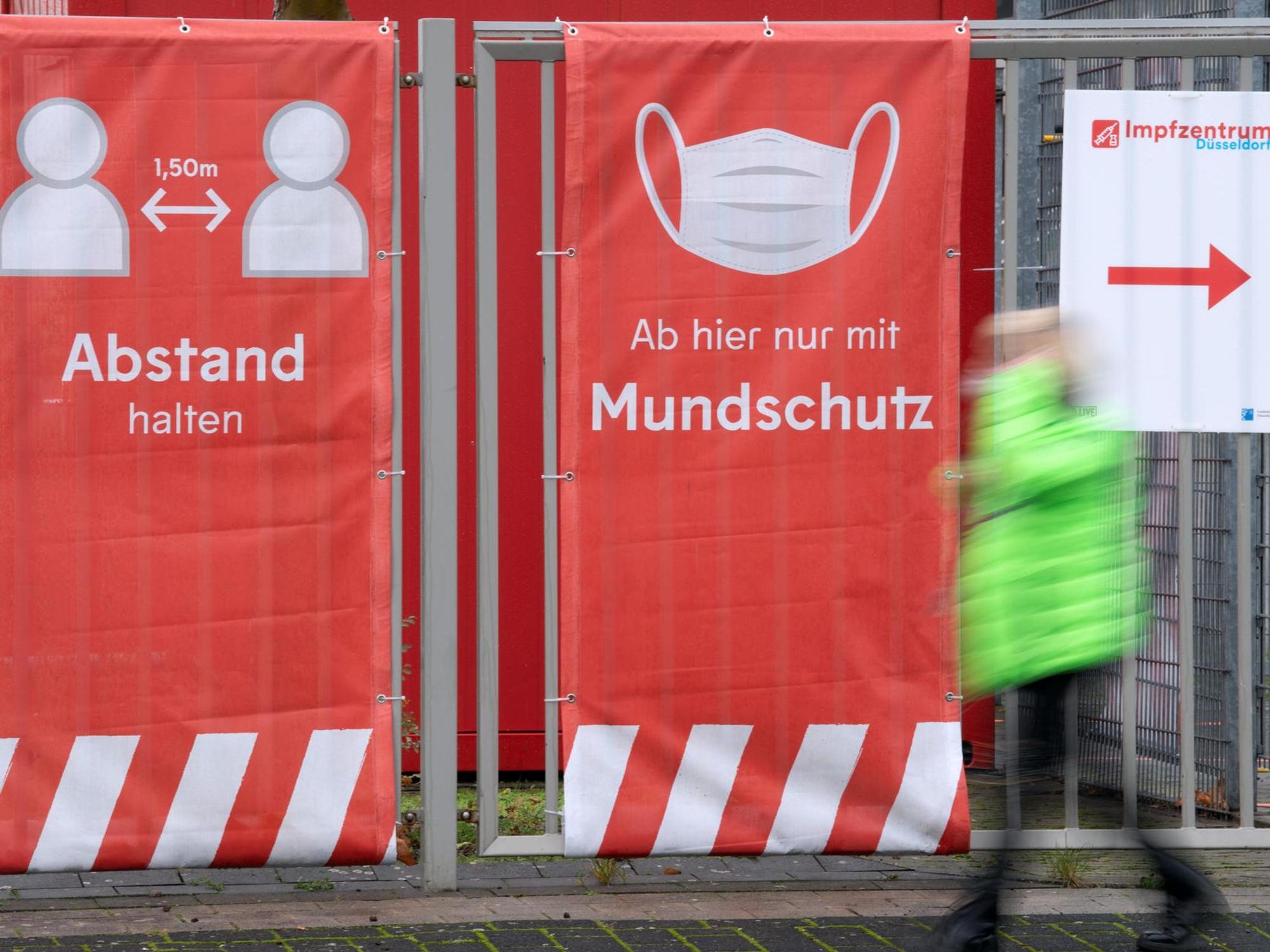 Ein Mann läuft an einem Impfzentrum vorbei.