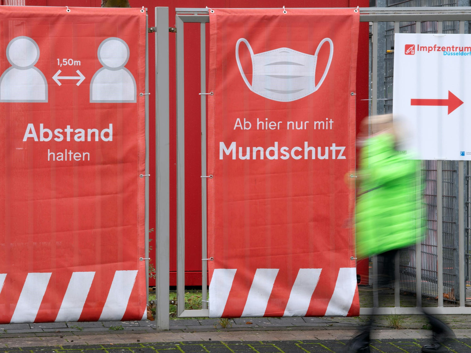 Ein Mann läuft an einem Impfzentrum vorbei.