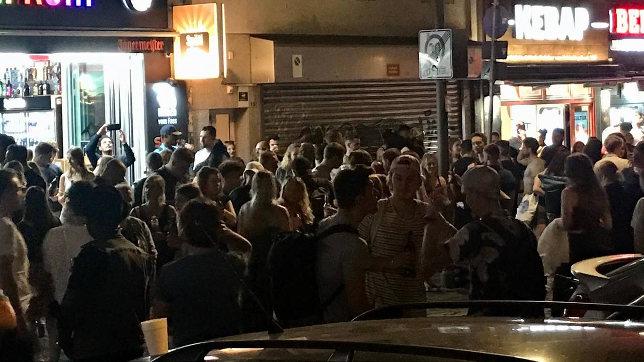 Viele Leute stehen dicht gedrängt vor einem Kiosk und anderen Lokalen an der Zülpicher Straße, Ecke Zülpicher Platz