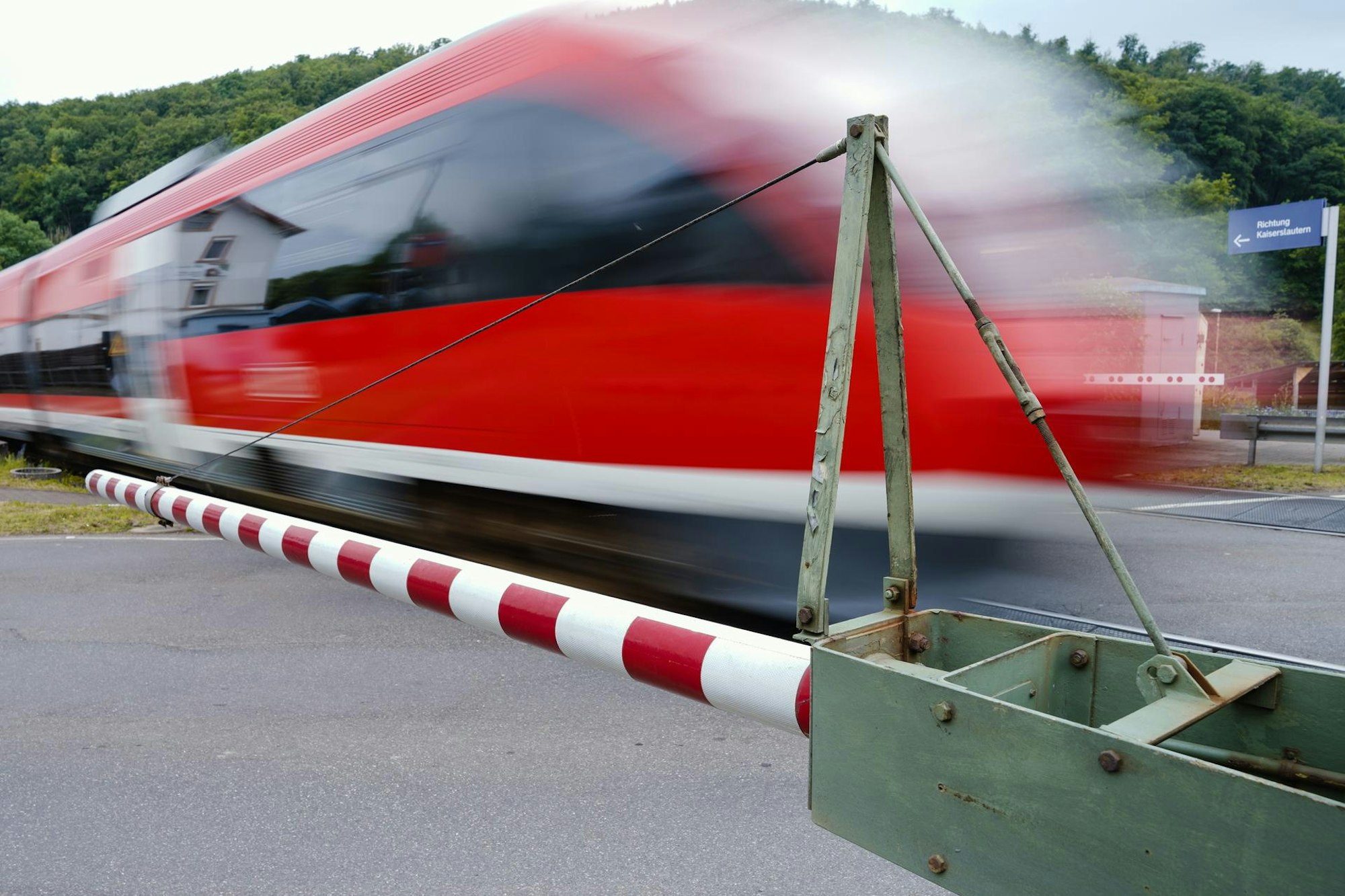 Ein Zug fährt bei geschlossenen Schranken vorbei