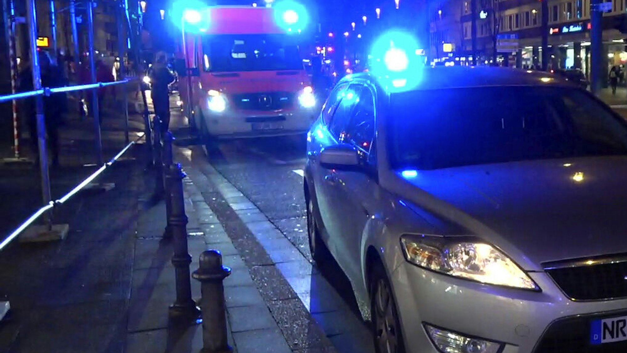 Ein Streifenwagen und ein Rettungswagen stehen an einer Straße.