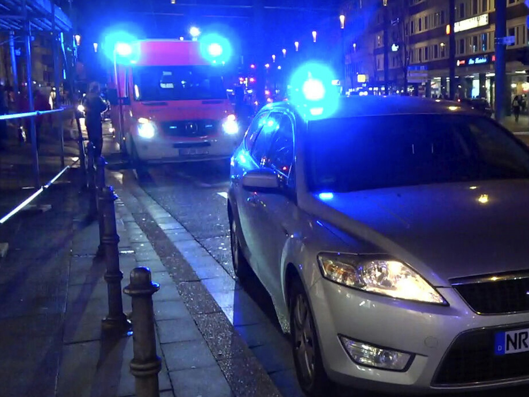 Ein Streifenwagen und ein Rettungsfahrzeug stehen auf einer Straße.