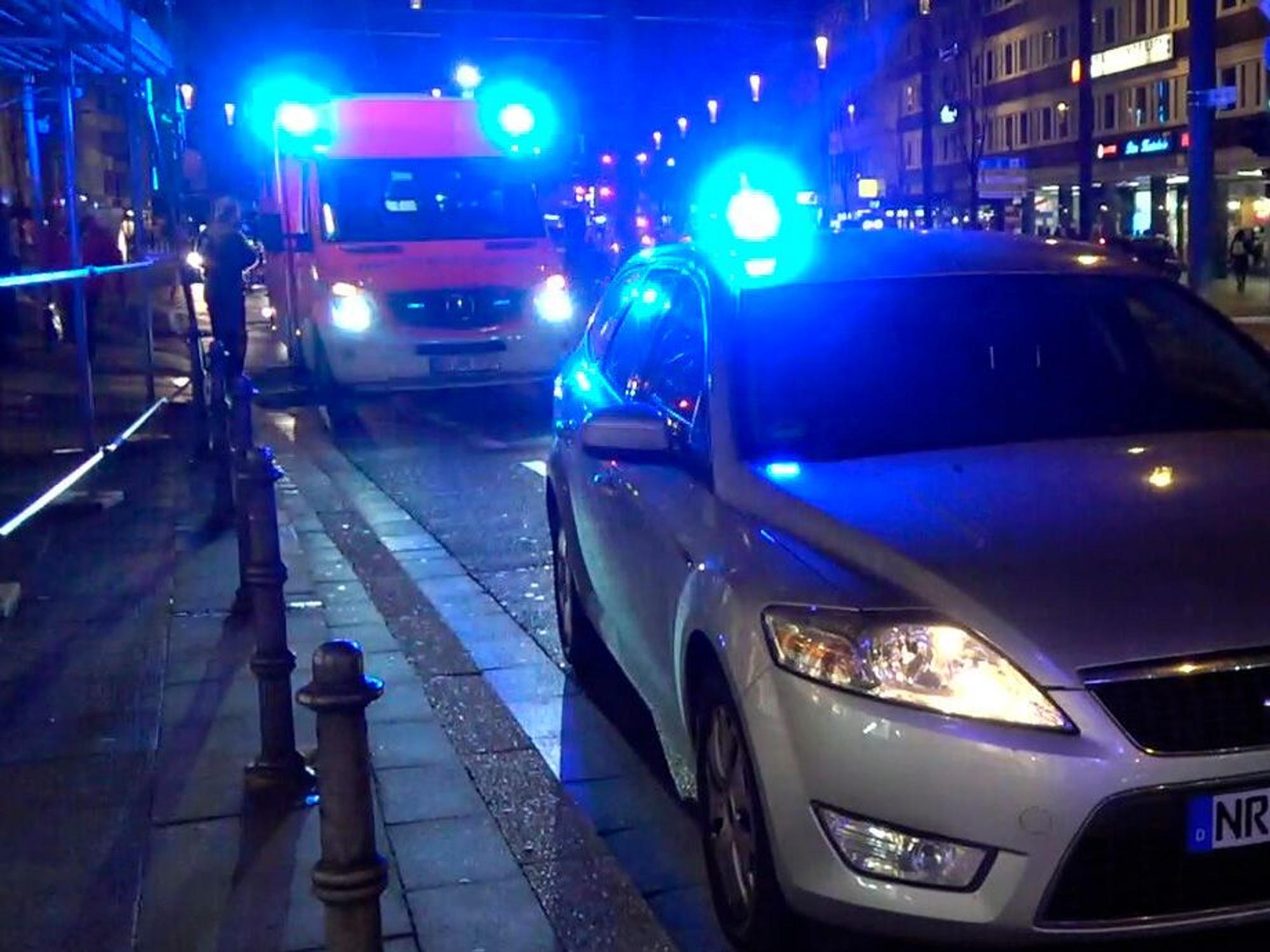 Ein Streifenwagen und ein Rettungsfahrzeug stehen auf einer Straße.