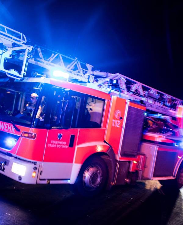 Ein Drehleiterwagen der Feuerwehr fährt mit Blaulicht.